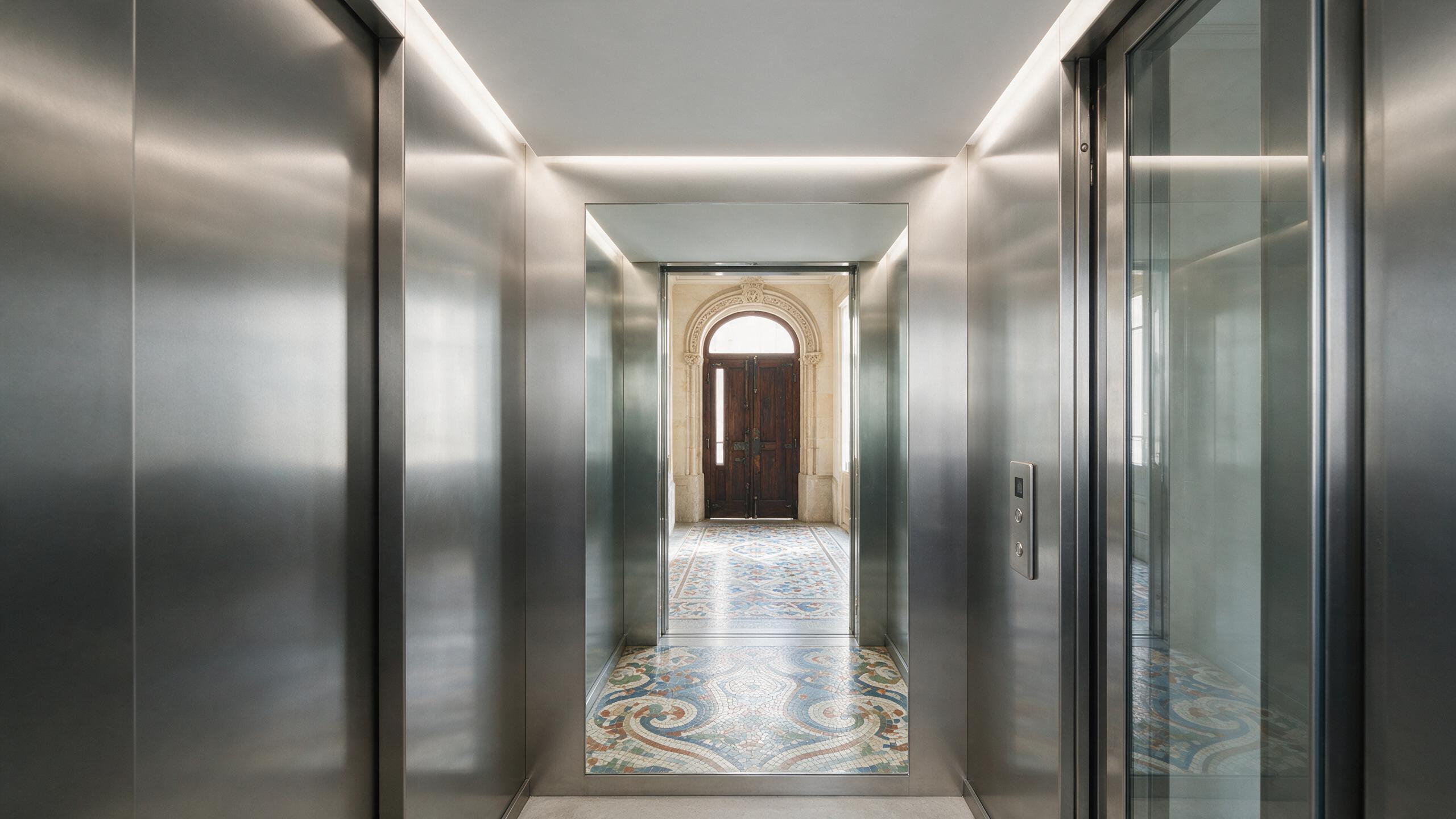 Cabina de ascensor moderna de acero en el portal de una finca del Eixample de Barcelona