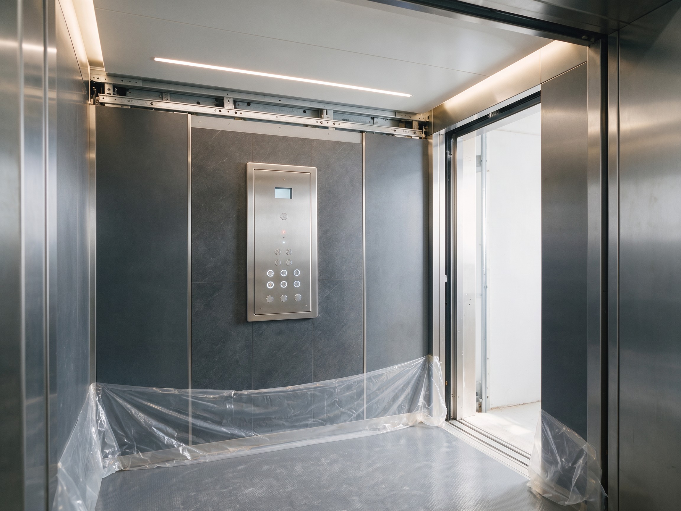 Cabina de ascensor de acero en plena modernización, con su nuevo panel de mando